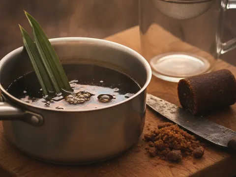 Gula melaka dicincang dimasak dengan air dan daun pandan sehingga larut menjadi air gula pekat berwarna gelap