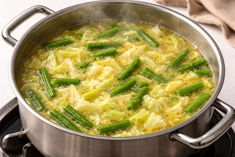 Karot dan sengkuang dimasak dalam kuah kuning yang mendidih