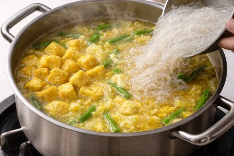 Kacang panjang, fucuk, dan suun dimasak dalam kuah lodeh yang mendidih