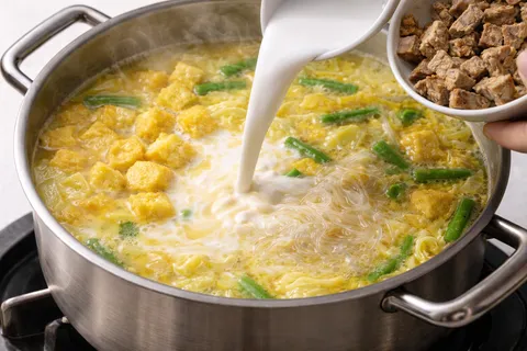 Santan pekat dituang ke dalam kuah lodeh, tauhu goreng dan tempe dimasukkan