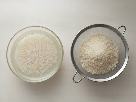 Beras basmati direndam dalam mangkuk berisi air jernih di atas meja dapur