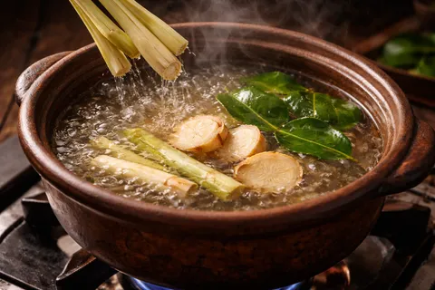 Aromatics serai, lengkuas dan daun limau purut sedang direbus dalam periuk air mendidih